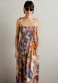 Maksijun s živopisnim paisley uzorkom, prozračna tkanina, smočeni bodice, tanke naramenice, lepršava suknja i blagi sjaj.