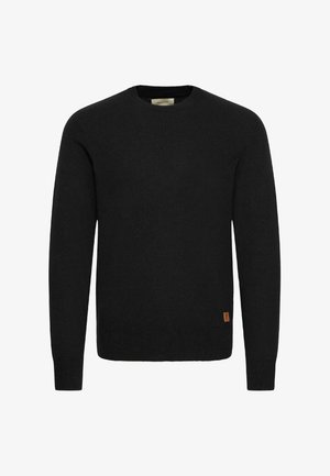 Melnā adīta džemperis ar apaļu kakla izgriezumu un garām piedurknēm. Apakšējā kreisajā pusē ir neliela brūna etikete. Gluda tekstūra.