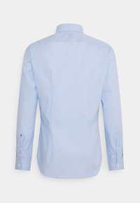 Jasnoniebieska koszula z długim rękawem i mankietami na guziki, widziana od tyłu na jednolitym tle.