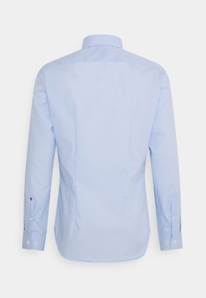 Jasnoniebieska koszula z długim rękawem i mankietami na guziki, widziana od tyłu na jednolitym tle.