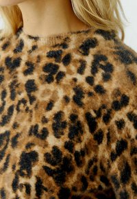 Luipaardprint trui met een zachte, fuzzy textuur in tinten bruin en zwart, ronde halslijn en een relaxte pasvorm.