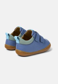 Leder-Kinderschuhe in Blau mit grünen und hellblauen Akzenten. Verfügt über zwei Klettverschlussriemen und eine braune Gummisohle. Abgerundete Form, glatte Textur.
