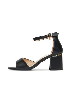 Czarna sandałka na obcasie z paskiem wokół kostki, odkrytymi palcami, gładką skórzaną cholewką oraz masywnym słupkowym obcasem z metalicznym akcentem.