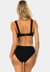 Czarny bikini w prążki z szerokim topem na ramiączkach i wysokim stanem. Teksturowany materiał o bezszwowej konstrukcji. Widok z tyłu.