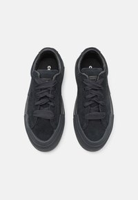 Sneakers negre din suede, cu vârf rotund, design cu șireturi, parte superioară texturată și talpă din cauciuc negru în contrast. Branding minim pe limbă.
