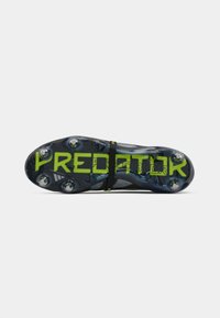Black soccer cleat with green "PREDATOR" text, featuring a textured sole and four round studs, designed for traction on grass surfaces.