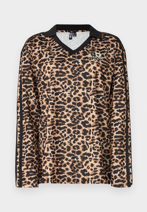 Chemise à manches longues imprimée léopard en beige et noir, avec un col en V et des accents noirs le long des manches. Fabriquée en tissu synthétique lisse.