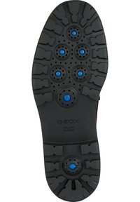 Svart gummisula med ett mönster och cirkulära blå ventilationshål samt präglad text "GEOX ITALIENSK PATENT".