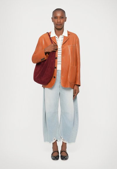 Tan leren blazer met twee voorkleppen, witte gestreepte shirt, lichtblauwe wijde jeans, en bordeauxrode schoudertas. Zwarte schoenen met bandjes.