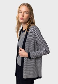 Randig cardigan i marinblått och vitt, med en mjuk stickad textur, öppen framsidan och långa ärmar med kontrasterande manschetter.