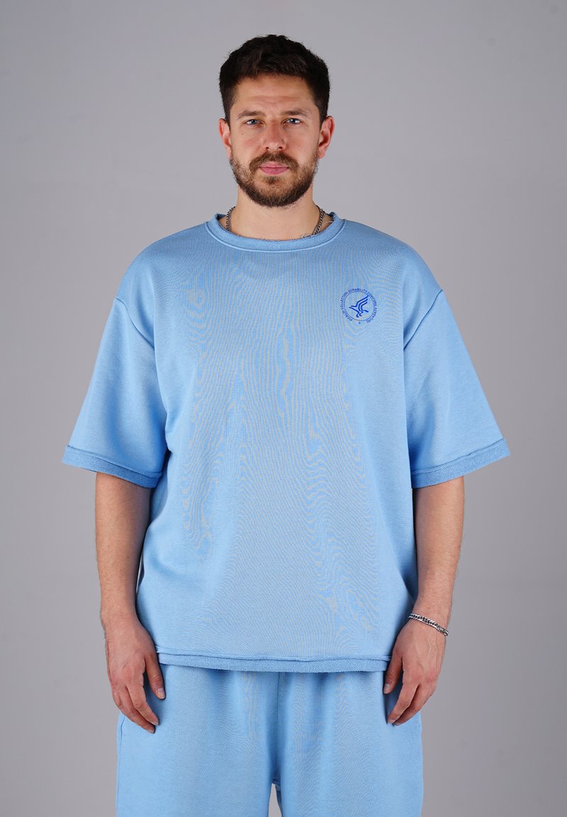 Light blue oversized sweatshirt with short sleeves, made of cotton, featuring a round neckline and a small logo detail on the chest.