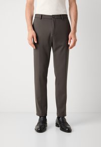 Dark brown, straight-fit trousers made of smooth fabric, featuring a button closure and side pockets, styled with black loafers.