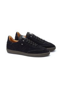 Zapatillas de ante negras con detalles perforados en los laterales, puntera redonda, cordones negros y suela de goma crema. Forro interior de cuero naranja.
