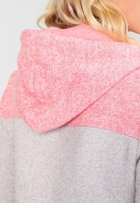 Hoodie met een tweekleurig ontwerp, met een roze textuurrijk bovenstuk en een glad lichtgrijs onderstuk. Zachte stof, casual pasvorm.