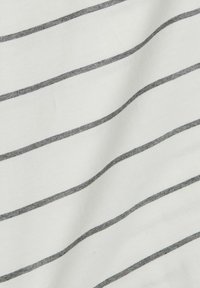 Tessuto di cotone con una texture liscia, caratterizzato da righe orizzontali grigie su uno sfondo bianco. Il materiale appare morbido e leggero.