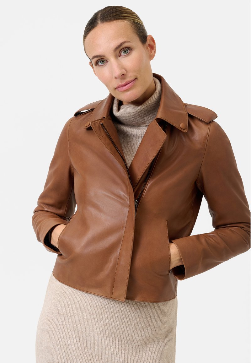 Bruine leren jas met een slim fit, brede kraag en twee zijzakken. De gladde textuur heeft een diagonale rits en knoopaccenten.