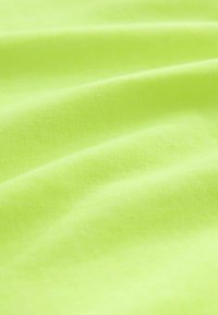 Bright yellow-green fabric with visible soft texture and gentle folds across the surface.