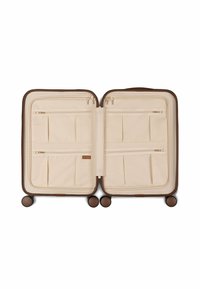 Beige travel suitcase with a brown frame, featuring multiple zippered pockets and compartments, set on four round wheels for mobility.