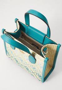 Lille flettet håndtaske med en krop af strå, turkise læderdetaljer, to håndtag og en snaplukning. Indvendigt er der en lynlåslomme.