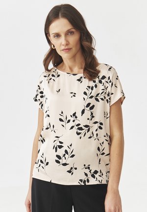 Haut floral en satin de couleur rose pâle avec un motif de feuilles noires, à manches courtes et col rond. Texture lisse avec une coupe décontractée.