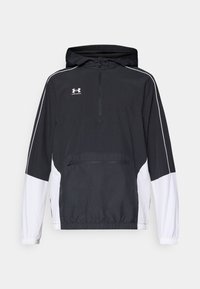 Sort og hvid pullover jakke med hætte, halv-lynlås foran, elastiske manchetter, frontlomme, hvide sidelæg og broderet logo på brystet.