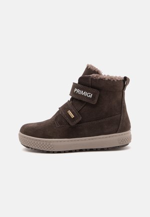 Botte d'hiver en daim marron avec deux brides Velcro, doublure en fausse fourrure et semelle en caoutchouc texturée, de la marque "PRIMIGI" pour enfants.