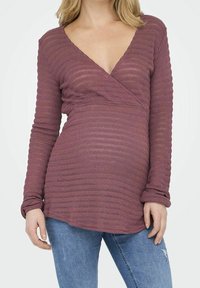 Haut à manches longues, de style portefeuille, en couleur mauve douce avec un motif rayé texturé. Caractérisé par un col en V profond et des manches amples.