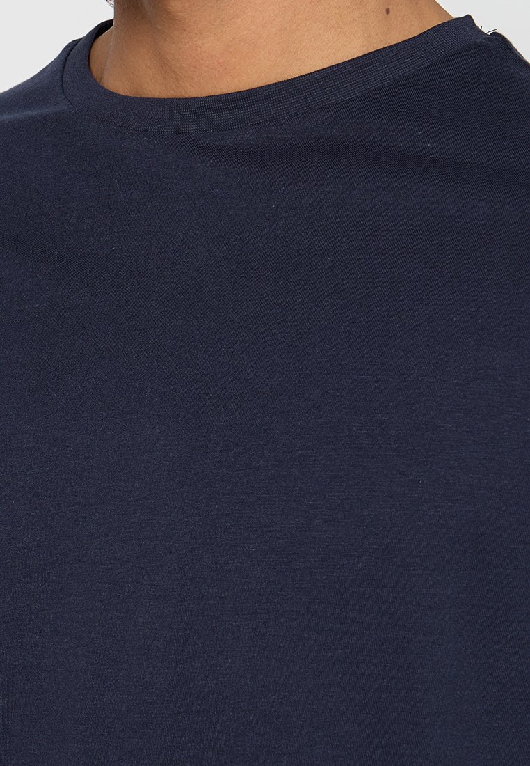 Marineblaue Baumwoll-T-Shirt mit Rundhalsausschnitt und kurzen Ärmeln, das eine weiche Textur und ein einfaches, nahtloses Design aufweist.