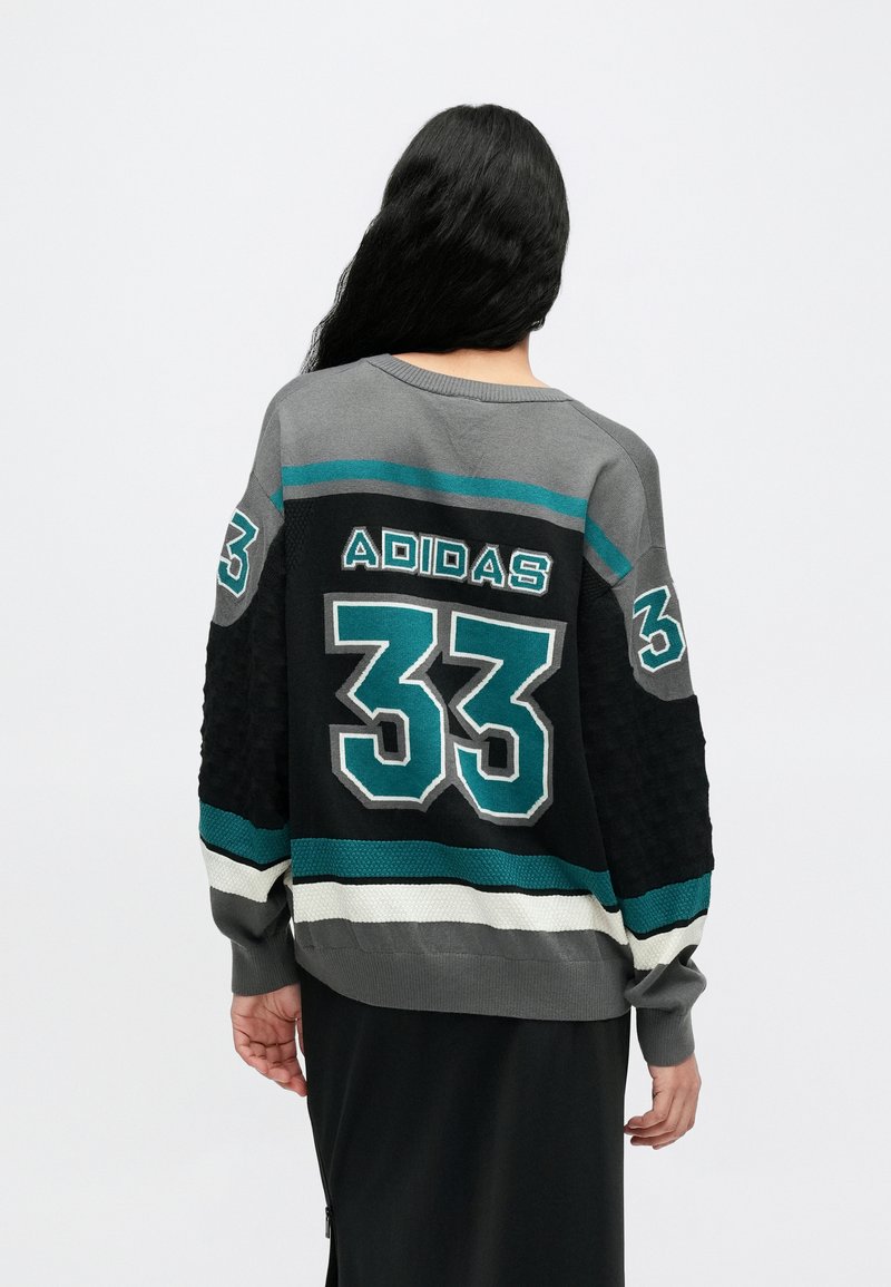 Pull en tricot gris et noir avec des accents turquoise. Présente le logo "ADIDAS" et le numéro "33" au dos, motif texturé sur les manches.