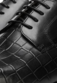 Černá kožená společenská bota s texturovaným krokodýlím vzorem, hladkým svrškem a tradičním šněrováním, kulatou špičkou a decentním prošitím.