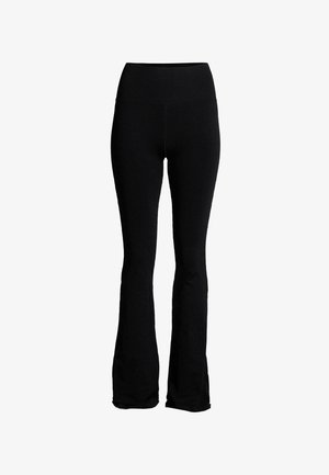 Leggings noirs évasés en tissu doux et extensible avec une taille haute. Ils présentent une texture lisse sans motifs ni éléments visibles.