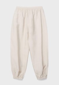 Pantalon beige ample avec ceinture élastique et poignets élastiqués froncés aux chevilles, présenté à plat sur un fond clair.