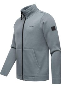 Graue Fleecejacke mit hohem Kragen, Frontreißverschluss und zwei Taschen für die Hände. Mit geripptem Design und einem Patch auf dem linken Ärmel.