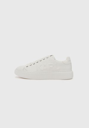 Hvite sneakers med en teksturert gummisåle og preget "KARL"-logo på siden. Har runde snørebånd og et glatt overmateriale.