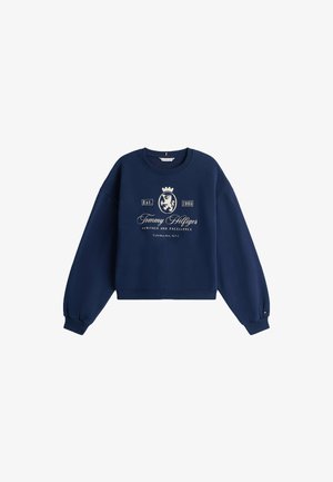 Sweatshirt bleu marine avec des manches longues et amples, des poignets côtelés et un col rond. Présente un logo blanc avec un design de couronne et de lion sur le devant.