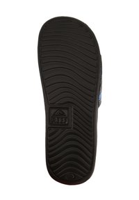 Black rubber sandal sole with a textured wave pattern, featuring a visible logo at the heel area. Durable and designed for traction.