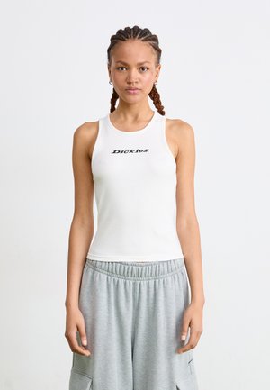 White ribbed tank top with black "Dickies" logo on the chest. Features a round neckline and sleeveless design, paired with grey sweatpants.