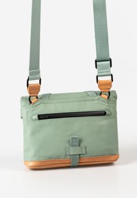 Borsa a tracolla in nylon verde con fondo beige, tracolla regolabile e tasca con zip sulla parte anteriore. Presenta accenti in hardware nero.