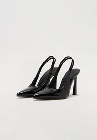 Juodos patentinės odos slingback kulniukai su smailiu nosiu, plonais dirželiais ir aukštu stiletto kulnu. Lygi, blizgi apdaila su minimalistiniu dizainu.