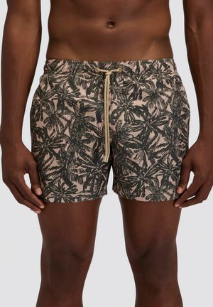 Parte centrale di un uomo che indossa pantaloncini da bagno beige con stampa di palme nere e coulisse beige.