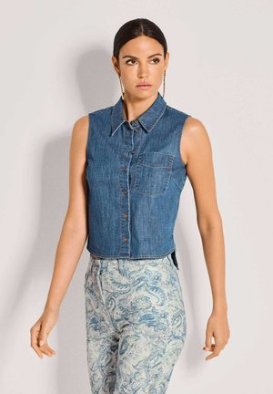 Sleeveless denim shirt in dark blue with a collared neck, front buttons, and a chest pocket; features raw edge and contrast stitching.