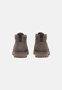 Brown leather ankle boots with a textured finish, featuring pull-tabs, reinforced stitching, and a durable rubber outsole.