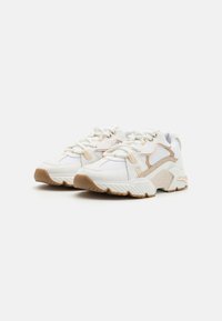 Białe sneakersy z beżowymi akcentami, siateczkowa i syntetyczna cholewka, gruba, gumowa podeszwa, okrągły czubek i sznurowany design. Teksturowane detale po bokach.