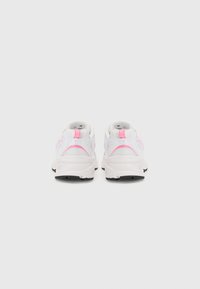 Baskets blanches de sport avec une tige en maille, des accents roses et une semelle extérieure noire épaisse. Le design comprend des cols rembourrés et des lacets.