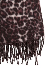 Bufanda de estampado de leopardo en marrón oscuro y crema, hecha de una tela suave con flecos en la parte inferior para añadir textura.