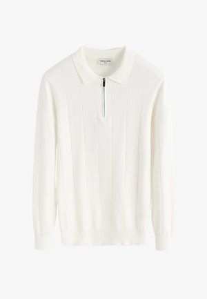 Pull en tricot blanc avec col et fermeture éclair mi-hauteur à l'avant. Présente un design côtelé vertical et des manches longues avec des poignets ajustés.
