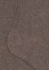 Calze marroni a coste con una texture morbida e dettagli di maglia fine, caratterizzate da righe verticali e punta rinforzata per una maggiore durabilità.