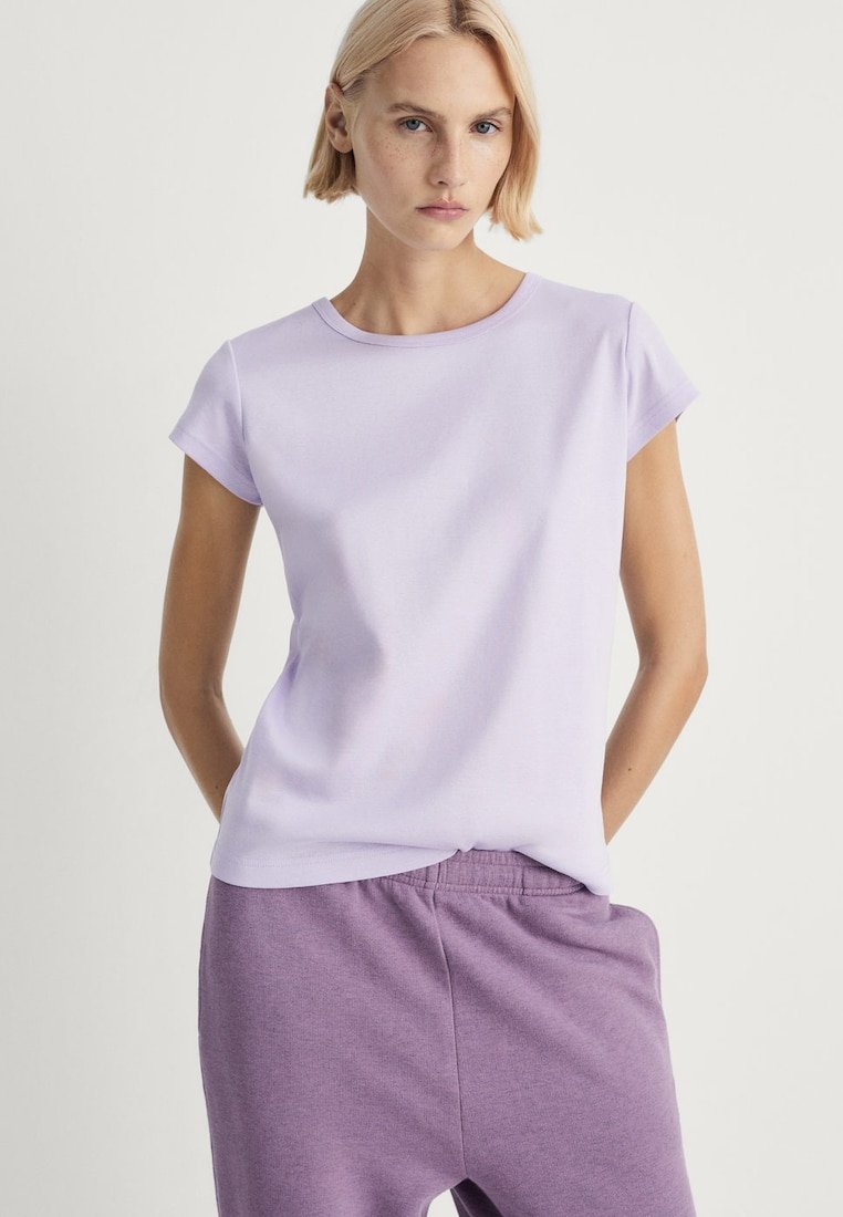 Lys lilla kortærmet t-shirt i blødt stof; klassisk rund halsudskæring og glat tekstur; parret med mørklilla sweatpants.