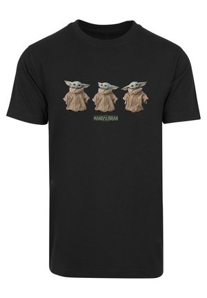 Musta puuvillapaita, jossa on kolme vihreäihovista sarjakuvahahmoa suurilla korvilla ruskeissa viitoissa, alla teksti "MANDALORIAN".