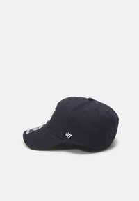 Gorra azul marino con visera curva, que presenta un logotipo bordado en blanco y una etiqueta de la marca 47 en el lateral. Fabricada con un tejido texturizado.